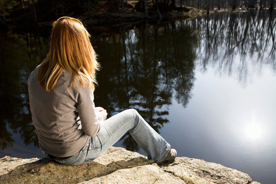 femme assise seule près de la rivière