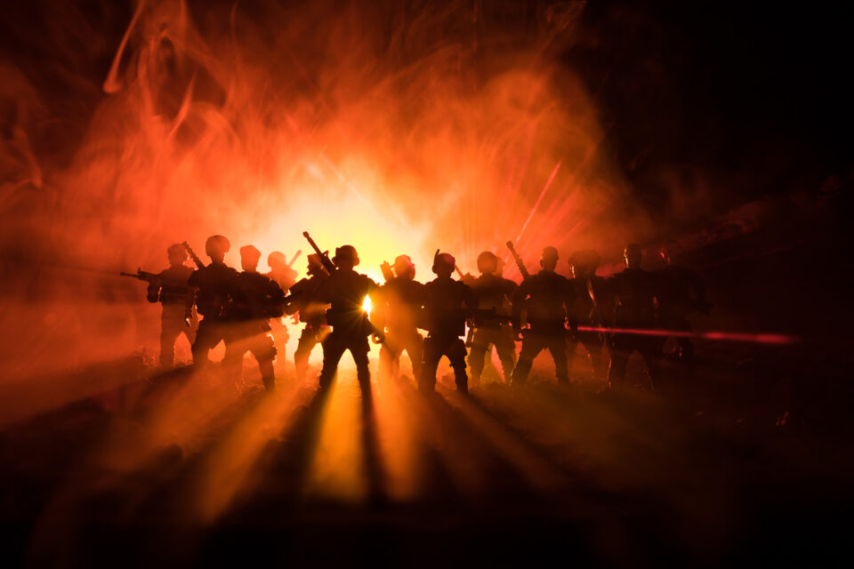 anti-riot police against background of flames and smoke